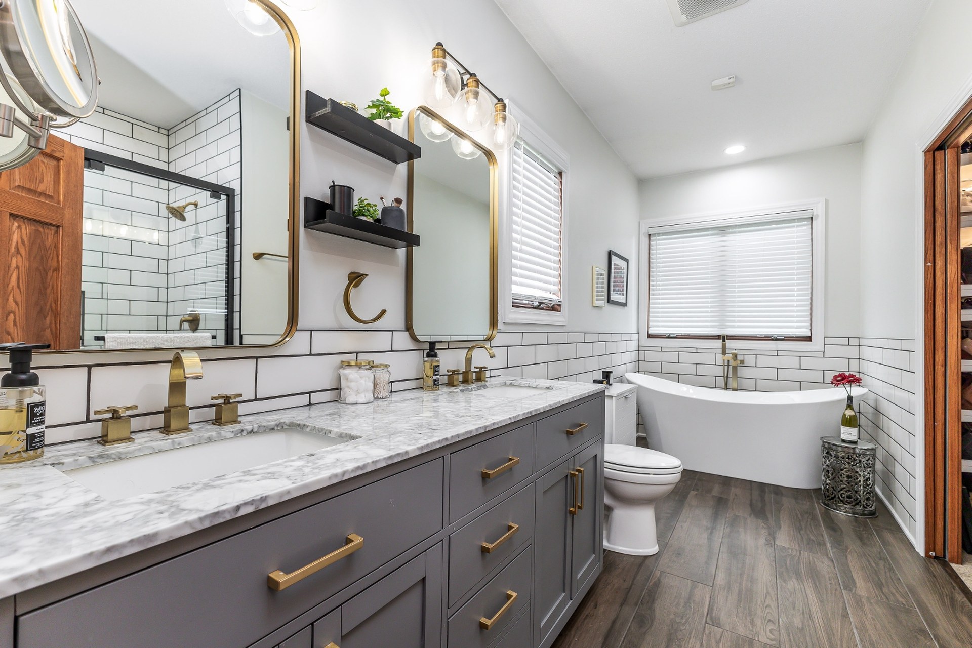 Luxury master bathroom with marble counters, gold fixtures, and freestanding tub — Kemp Court Dubuque